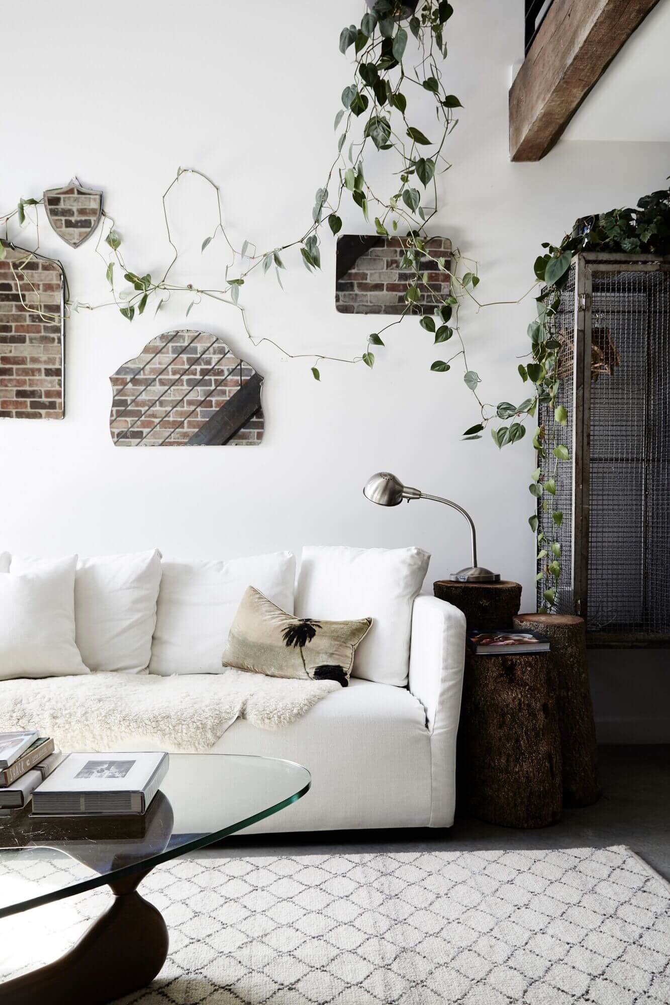 Lounge room at The Chapel, Byron Beach Abodes, with white linen sofa, vintage wall mirrors and hanging plants