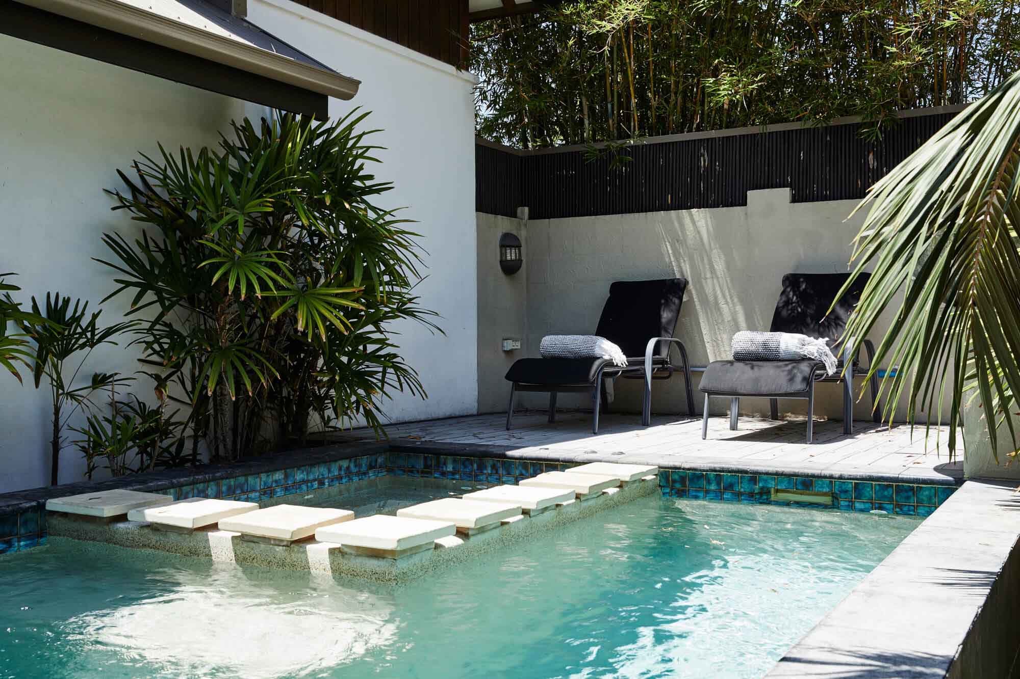 Black daybeds beside the private mineral pool and heated spa at The Villas of Byron