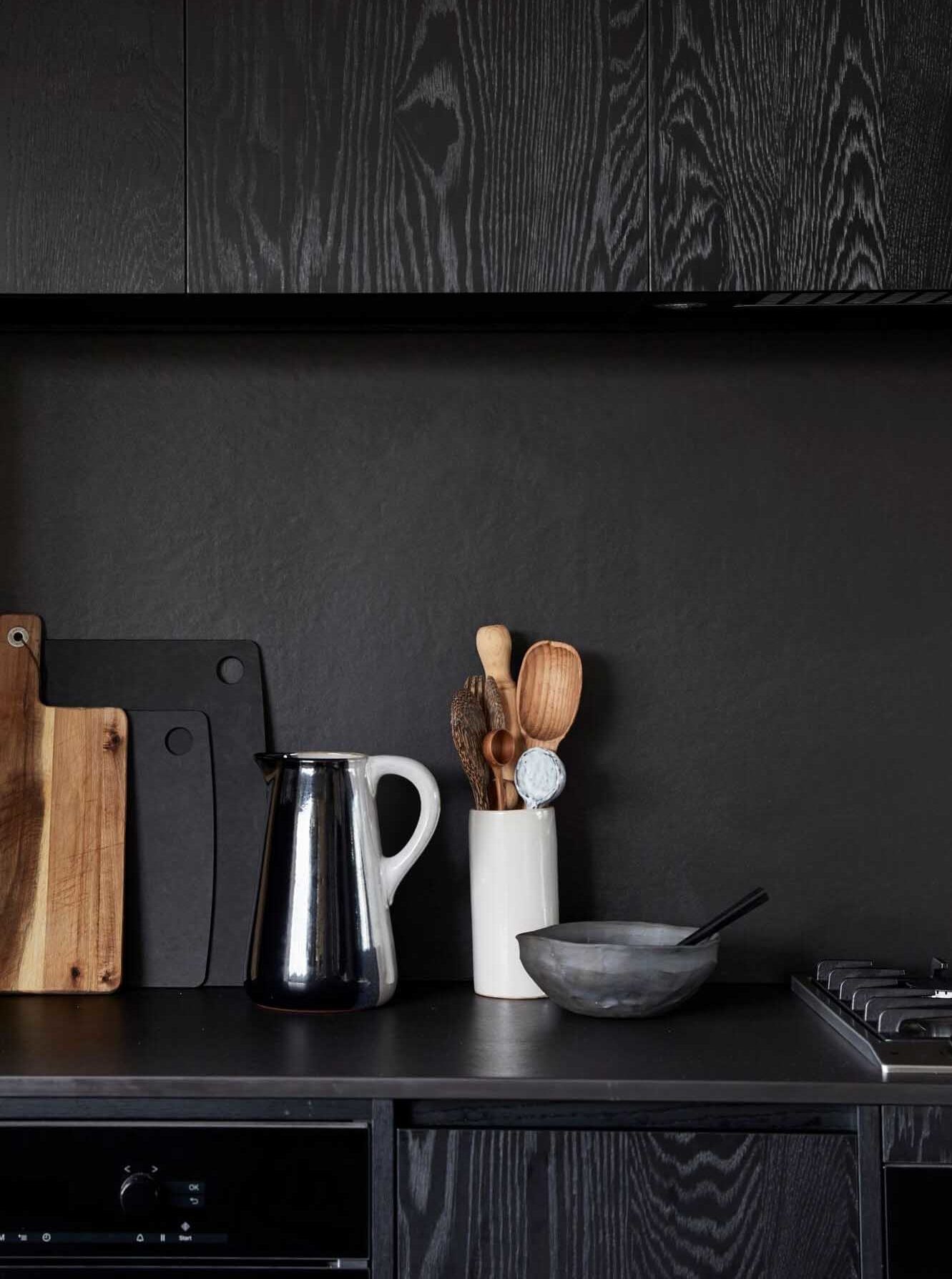 Black stone splashback and collection of vintage kitchen utensils at The Cabin, Byron Beach Abodes