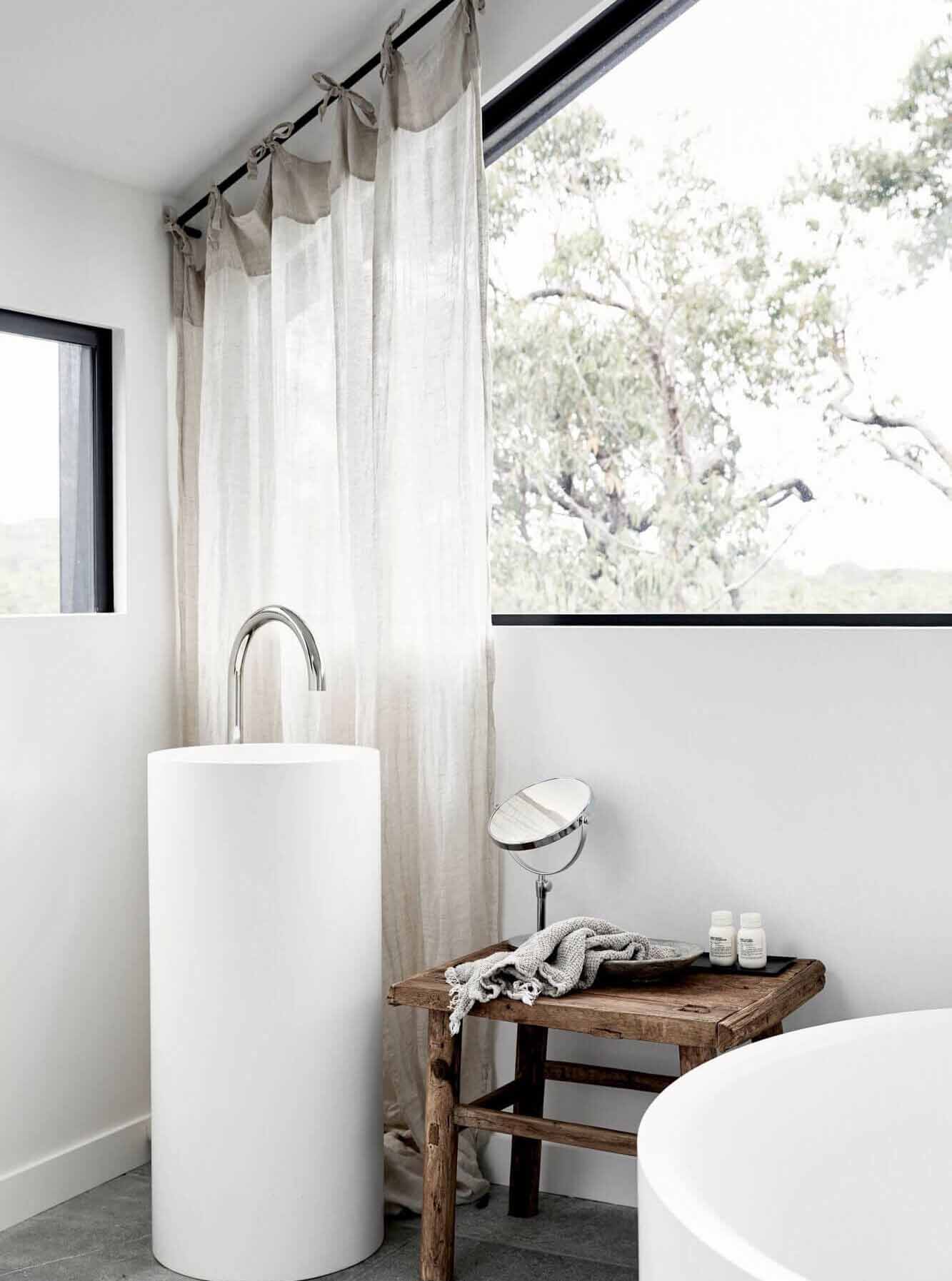 Round, cylindrical white stone washstand in The Cabin, Byron Beach Abodes ensuite