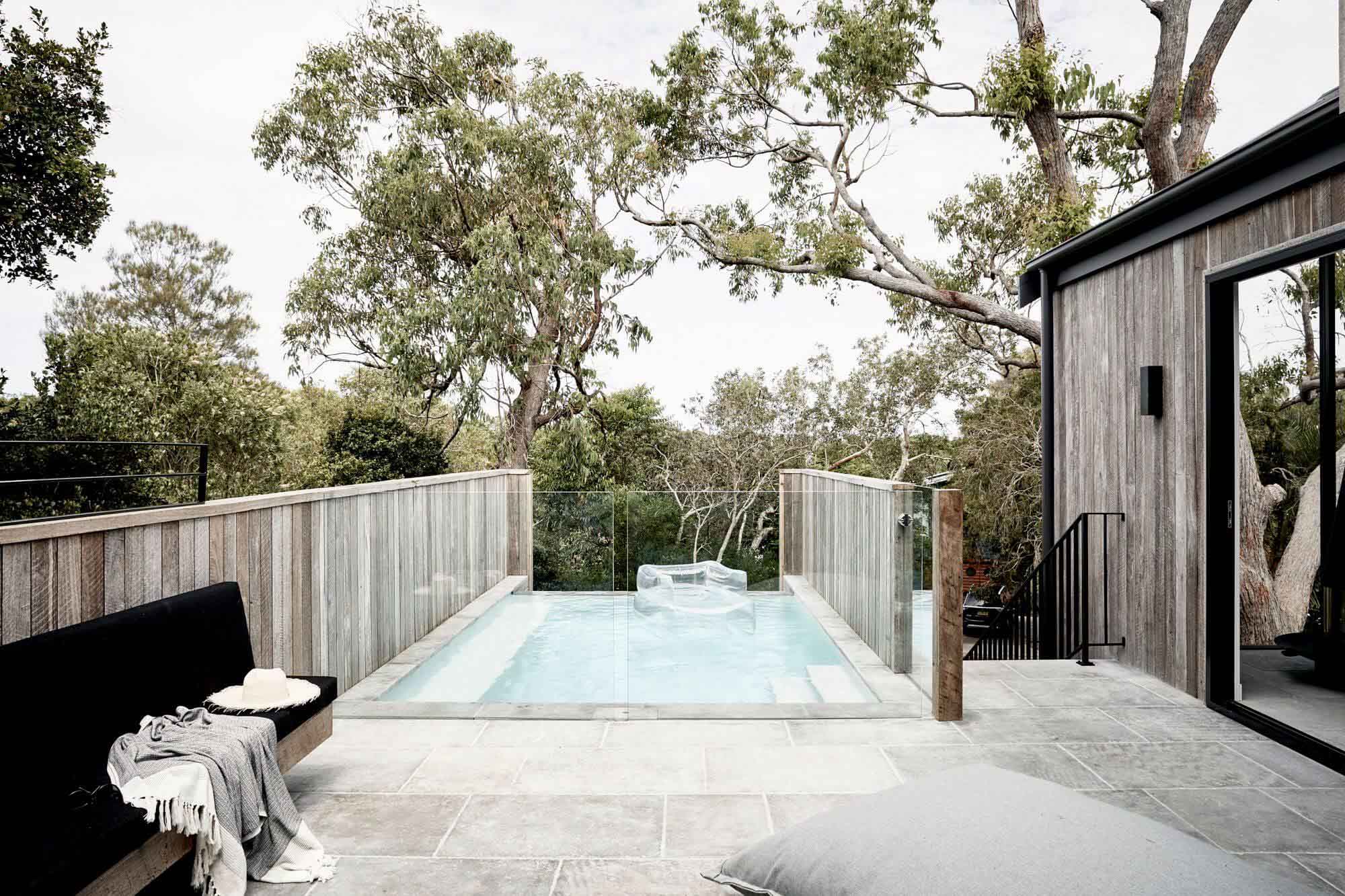 Mineral pool at The Cabin, Byron Beach Abodes, with glass pool fence and limestone paving