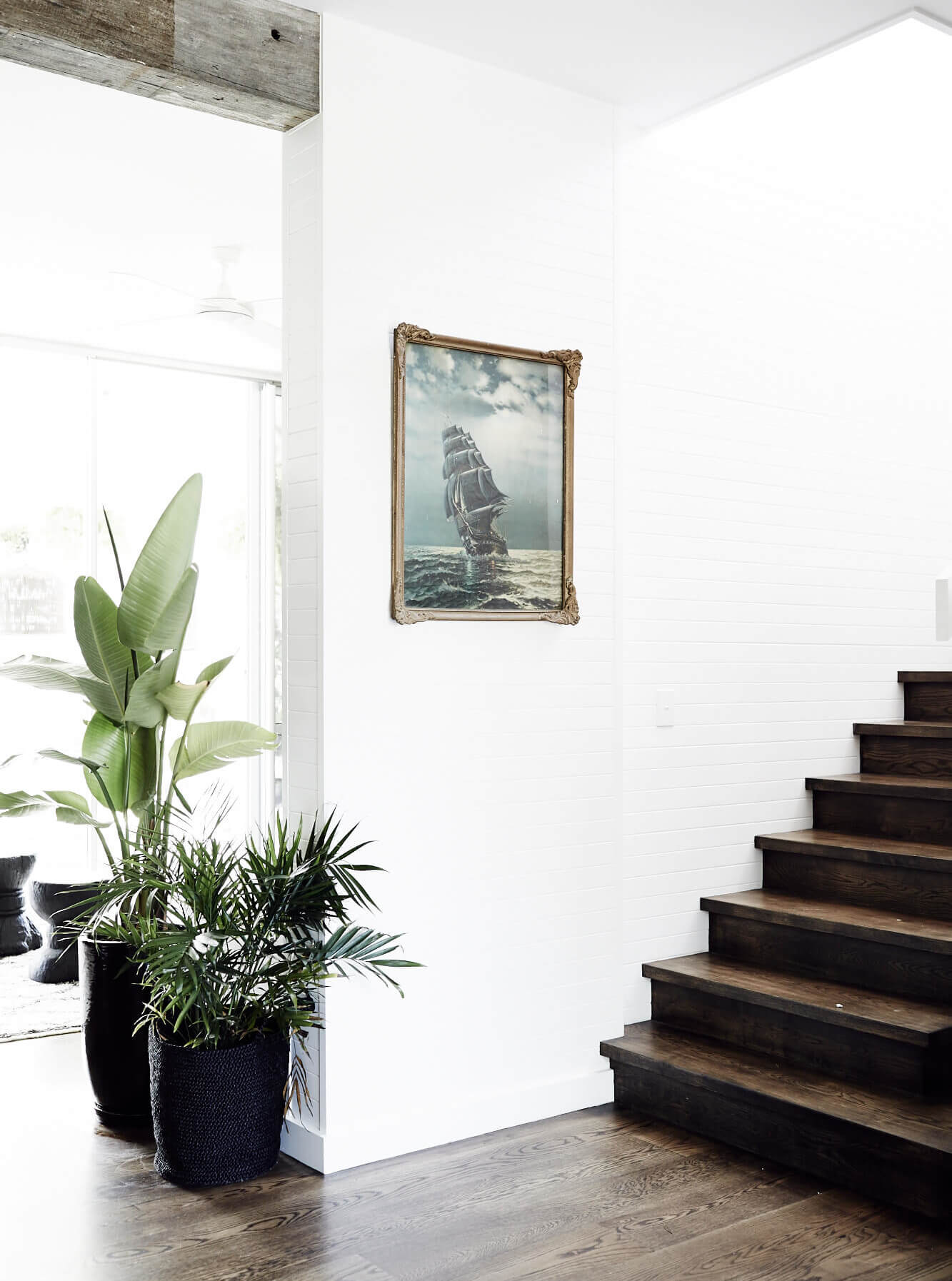 Stairway at Magnolia House, Byron Beach Abodes with lush indoor plants and vintage artwork