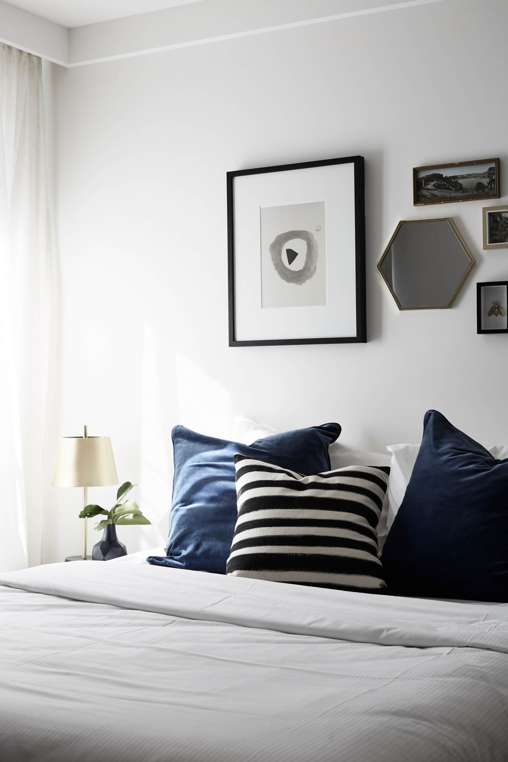 Bed at the Bower Suites, The Bower Byron Bay hotel with blue velvet cushions and curated wall art above