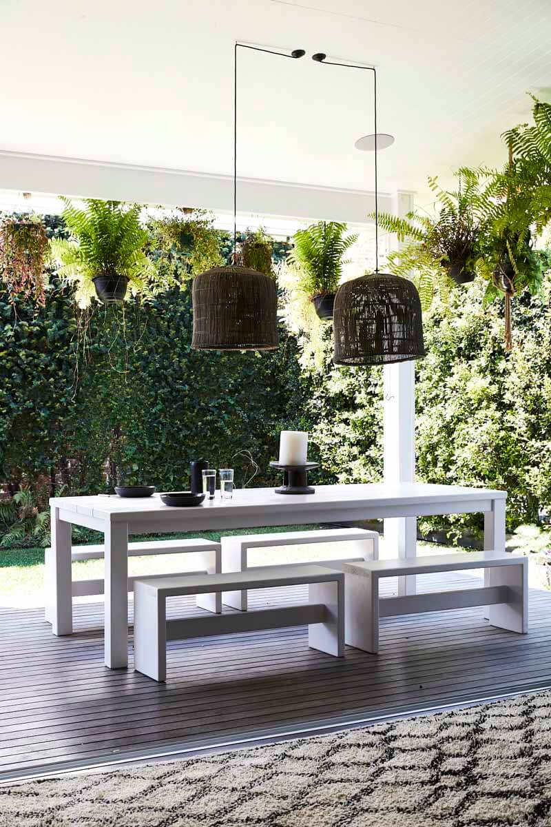 Outdoor dining area at Magnolia House, Byron Beach Abodes overlooking the lush green backyard