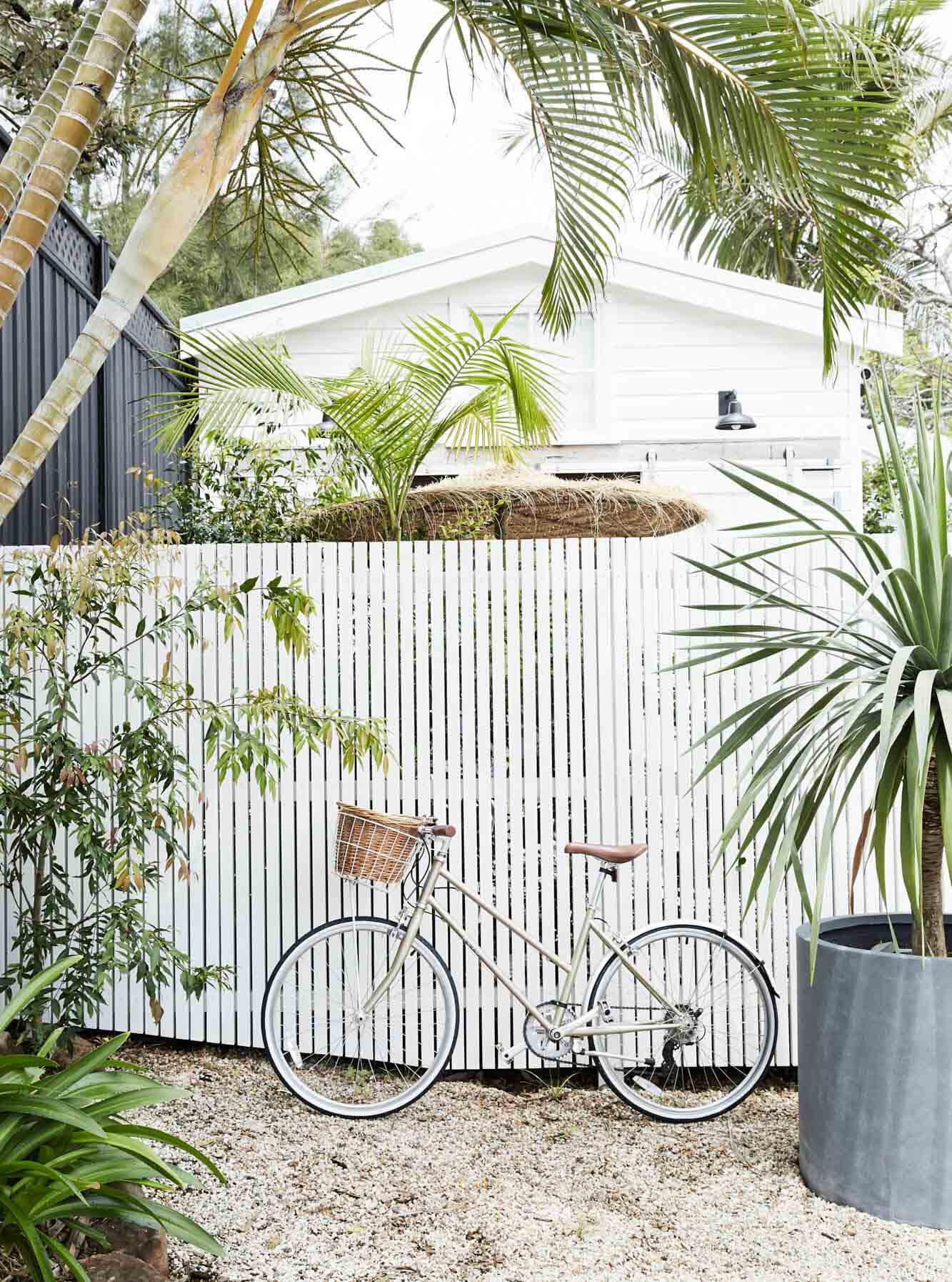 White bike with basket in front of white slatted fence at the Bower Barn, The Bower Byron Bay hotel