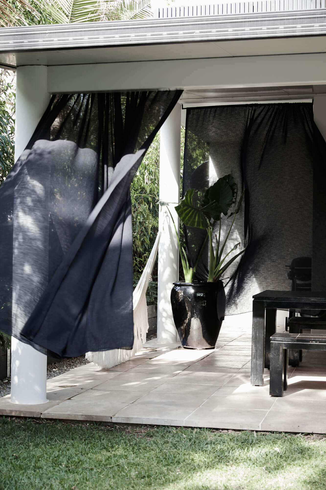Billowing black linen curtains giving privacy to Bower's House's undercover courtyard