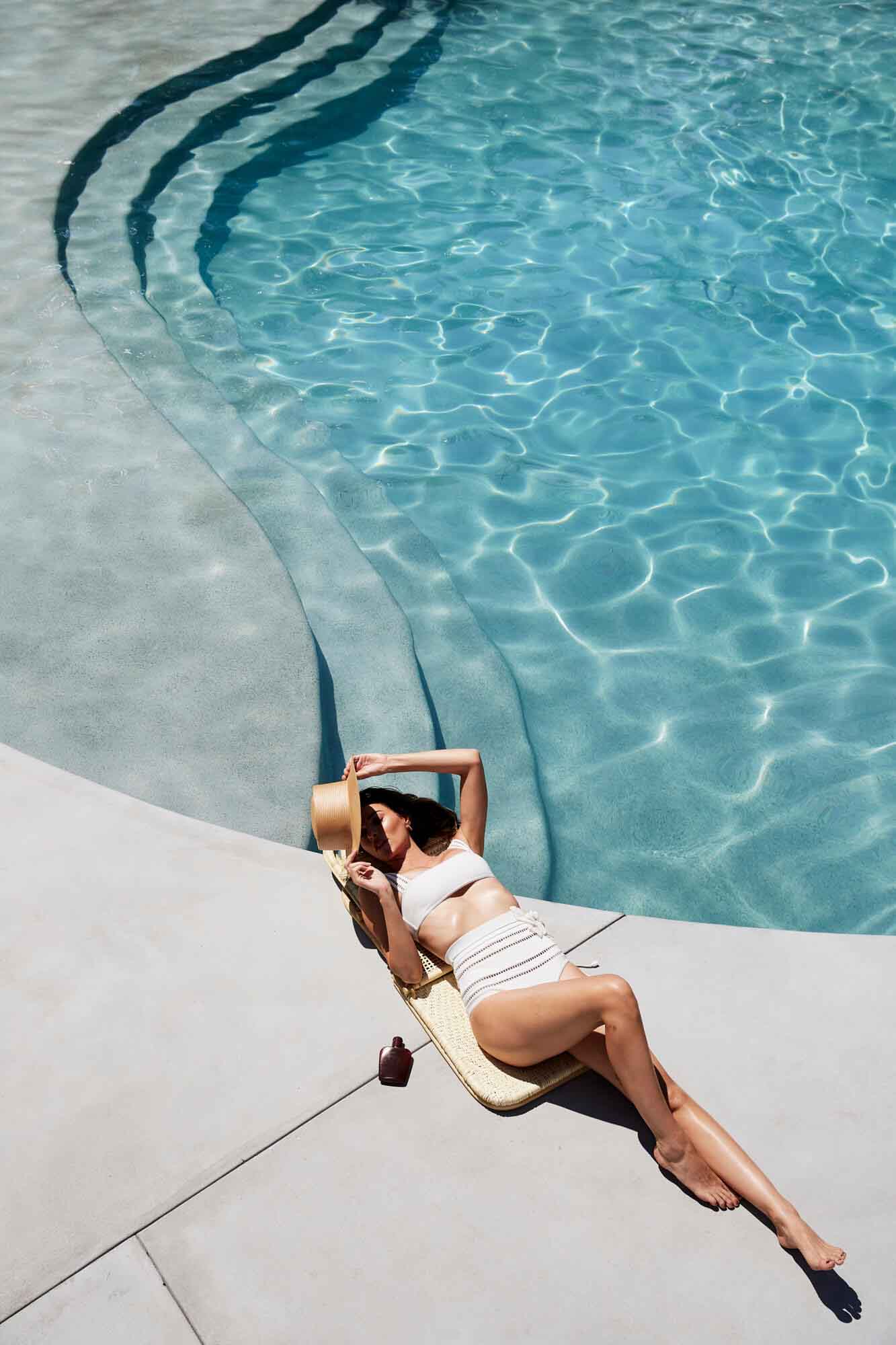 Woman sunbaking beside the pool at The Bower Byron Bay